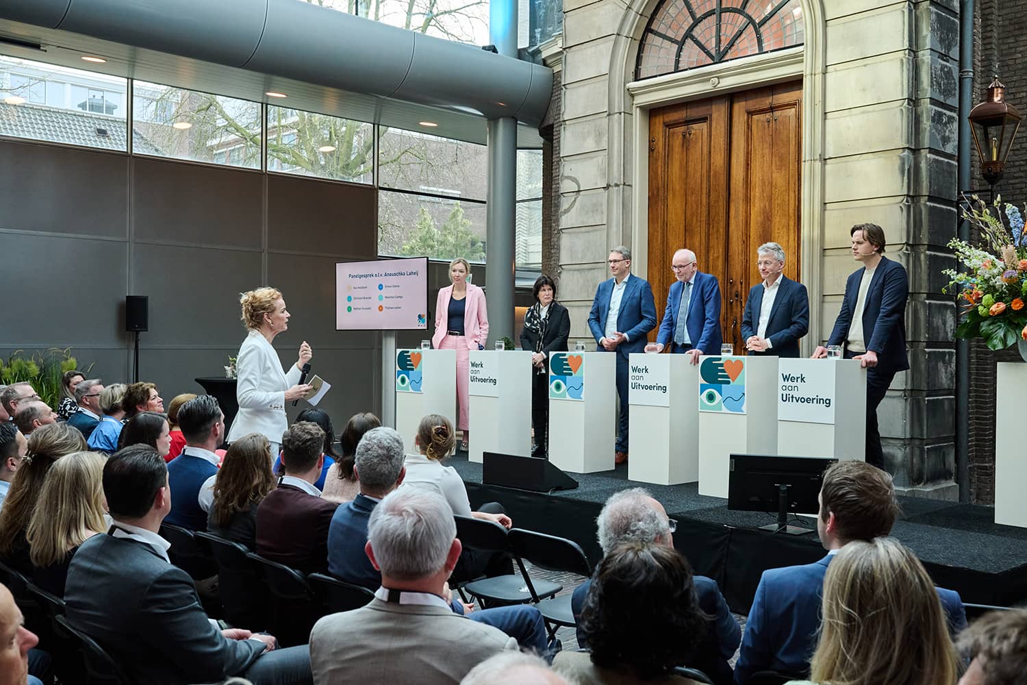 6 personen op het podium van de Glazen Zaal