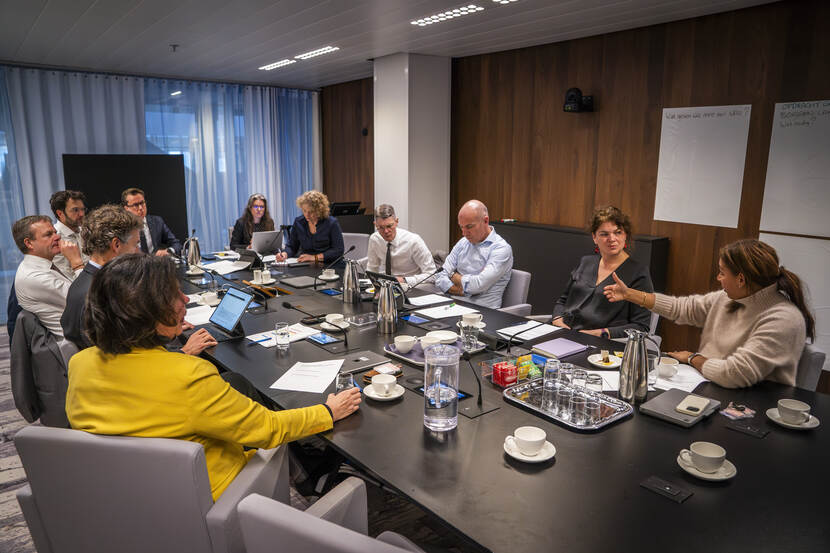 Elf personen aan een vergadertafel