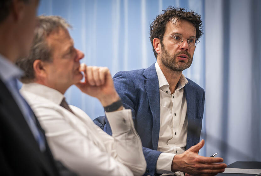 Man aan vergadertafel aan het praten