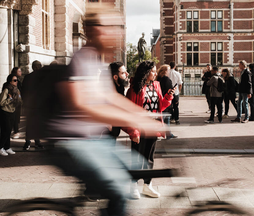 Vrouw die naar telefoon kijkt en voorbijgangers